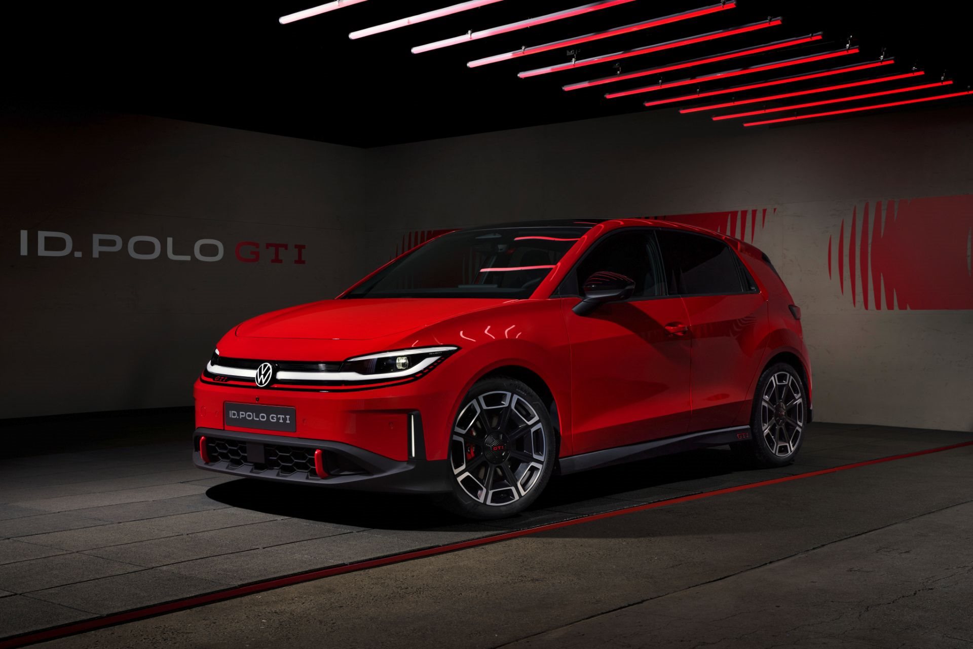 Red Volkswagen ID. Polo GTI in a studio under red light bars